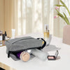 A gray embroidered travel cosmetic bag rests on a white table next to skincare products and a pink flower.