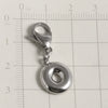 Silver stainless steel alphabet letter charm with a lobster clasp placed on a ruler.