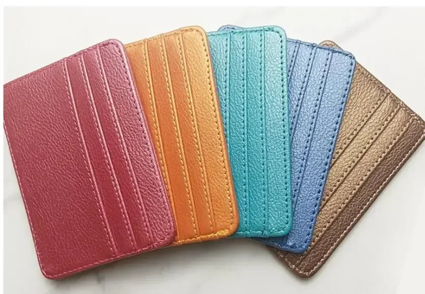 A row of five slim PU leather mini wallets in various shades including red, orange, teal, purple, and tan.