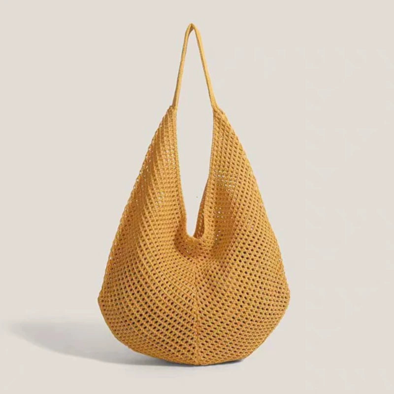 A mustard yellow crochet shoulder bag with a mesh detailing, shown from the front.
