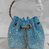 A bright blue crystal-embellished evening clutch with a silver chain strap is displayed against a white background.