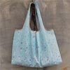 Light blue reusable shopping bag with a sheer fabric and small white animal patterns