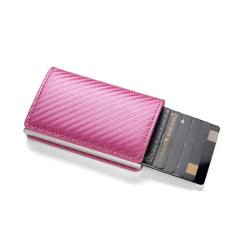 A pink quilted minimalist RFID blocking wallet holding several cards.