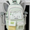 A light green backpack with a cat design and lace trim hanging on a white coat rack.
