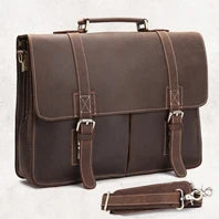 A brown genuine leather briefcase with leather straps and buckles is shown on a light background.