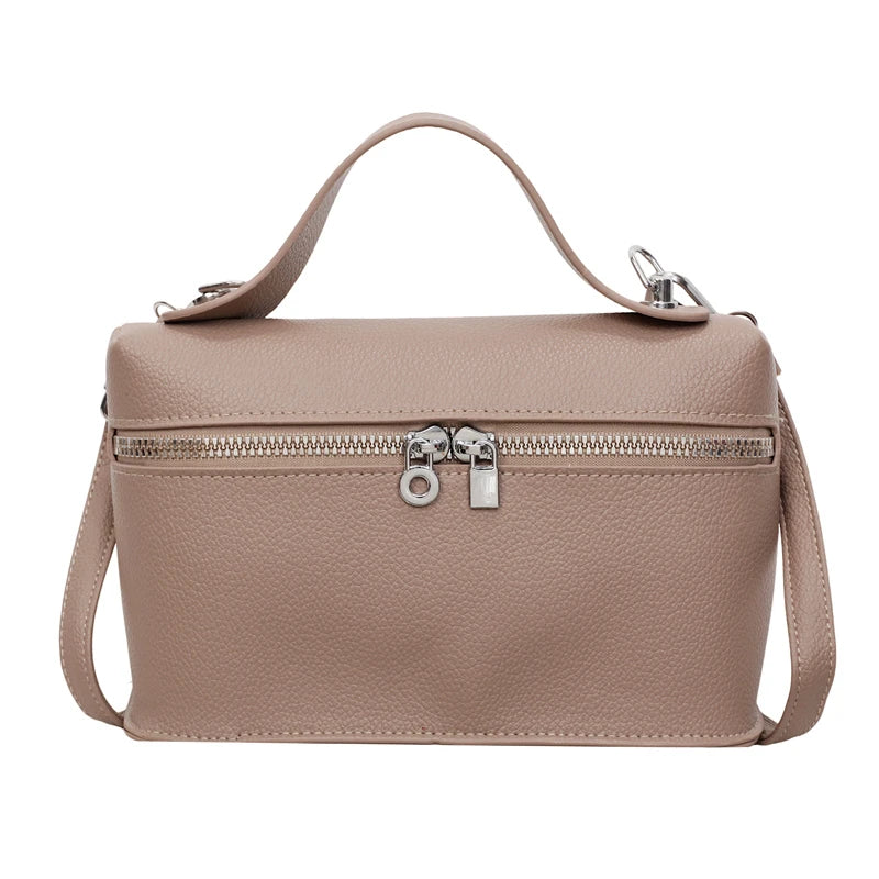 A beige pebbled leather box crossbody bag with a zipper closure and leather strap.