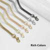 A collection of various metal chain bag straps in gold, silver, and black tones arranged diagonally.
