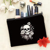Black makeup pouch featuring a detailed illustration of a skull surrounded by roses