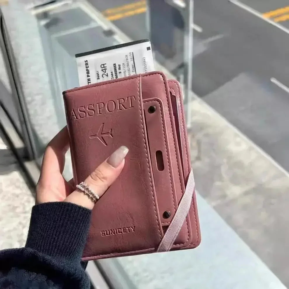 A hand holds a brown passport wallet with a leather cover and a visible passport inside.