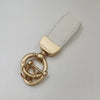 Goldfarbener Leder-Schafspurr-Anhänger mit weißer Canvas-Strap.