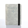 A light gray passport organizer wallet with a black trim and a silver airplane icon.