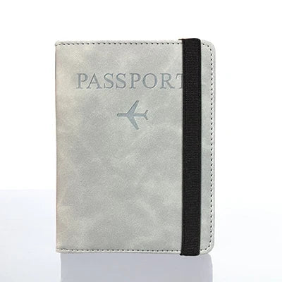 A light gray passport organizer wallet with a black trim and a silver airplane icon.