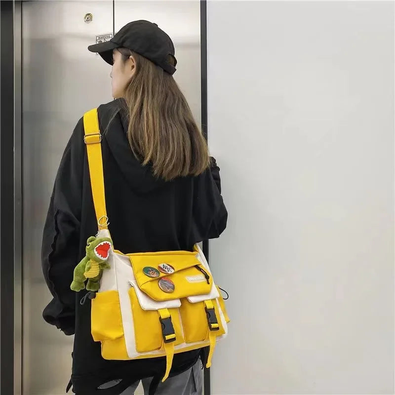 A woman wearing a black hoodie and hat is holding a yellow nylon crossbody shoulder bag.