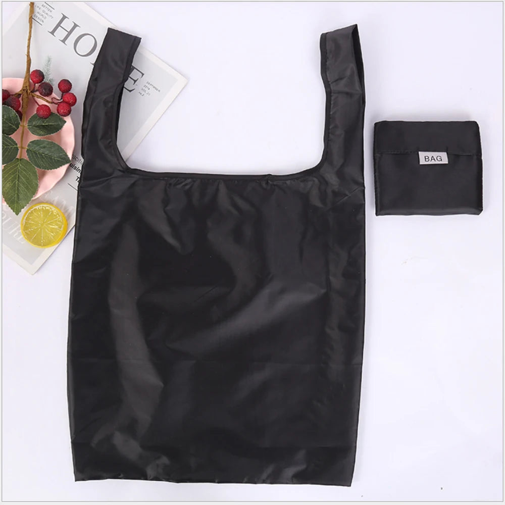 A black eco-friendly foldable shopping bag is shown against a white background.