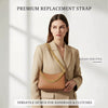 A woman models a tan blazer and a brown handbag featuring a gold metal chain replacement strap.