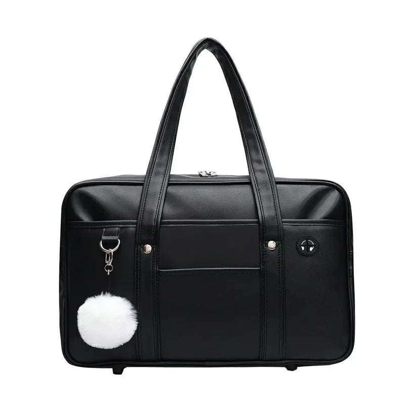 Black leather preppy shoulder bag with a white pom-pom detail