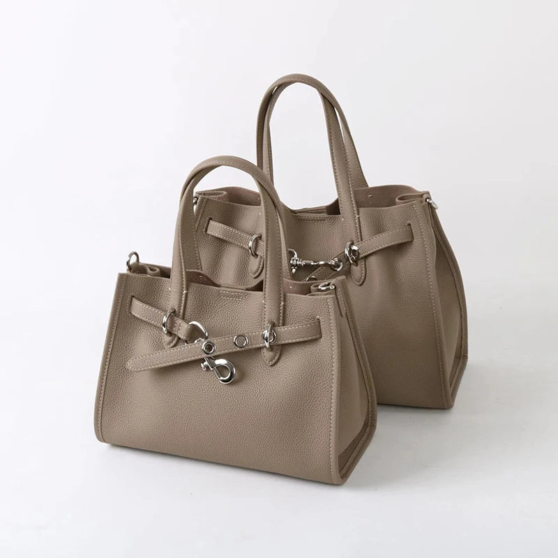 A beige genuine leather women's shoulder tote bag with leather handles and hardware.