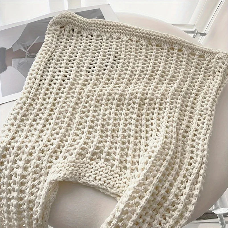 A cream-colored bohemian knit shoulder bag displayed on a white surface.