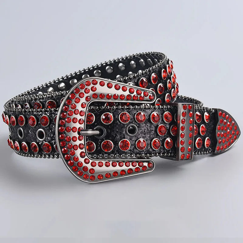 A silver decorative western buckle belt featuring red rhinestones and black studs on a leather strap.