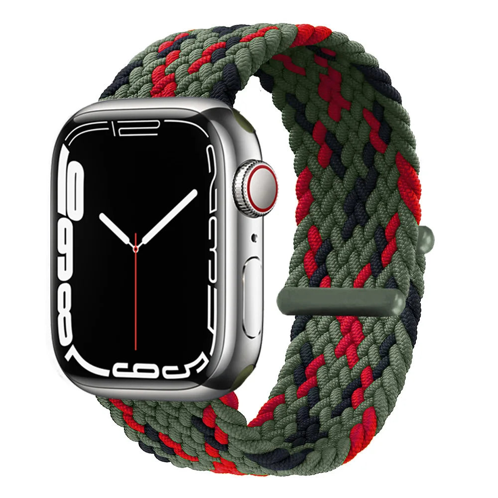 A silver Apple Watch is shown with a dark green braided stretch band wrapped around it.