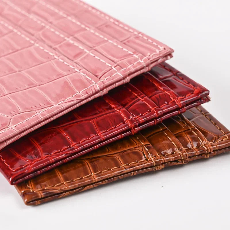 Stack of three pink, red, and brown crocodile-textured PU leather card holder wallets.