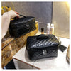 Black quilted makeup storage pouch with gold hardware resting on a marble surface.