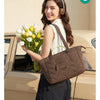 A woman holds a brown quilted tote bag with a detachable strap and a bouquet of white and yellow tulips next to a vintage car
