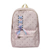 A light pink corduroy backpack with a bow print and light blue accents.