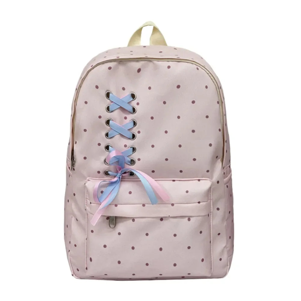 A light pink corduroy backpack with a bow print and light blue accents.