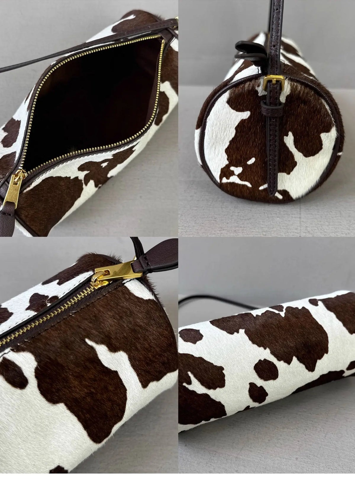 A brown and white cow print cylinder shoulder bag with a gold zipper detail.