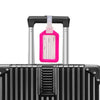 A black suitcase with a pink luggage tag attached to the handle.
