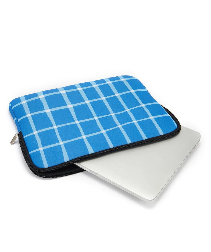 A bright blue plaid laptop sleeve with a black zipper is shown next to a white laptop.