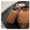 A brown leopard print tote bag with tan leather handles is shown resting on a dark gray blazer.