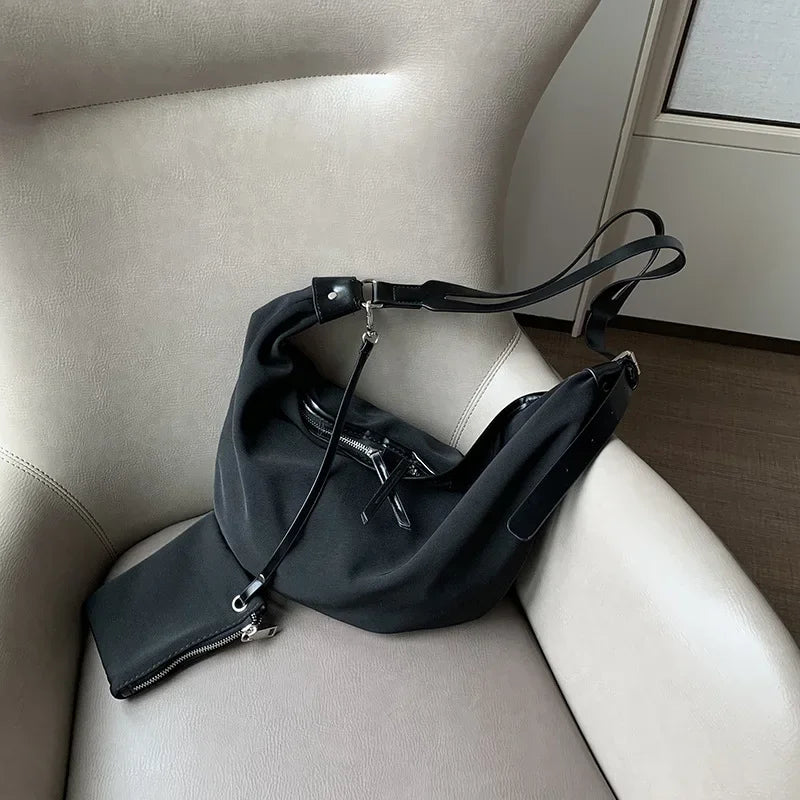Schwarze Leinensonne mit Zebra-Print, Schultertasche, auf einem hellen Lederstuhl.