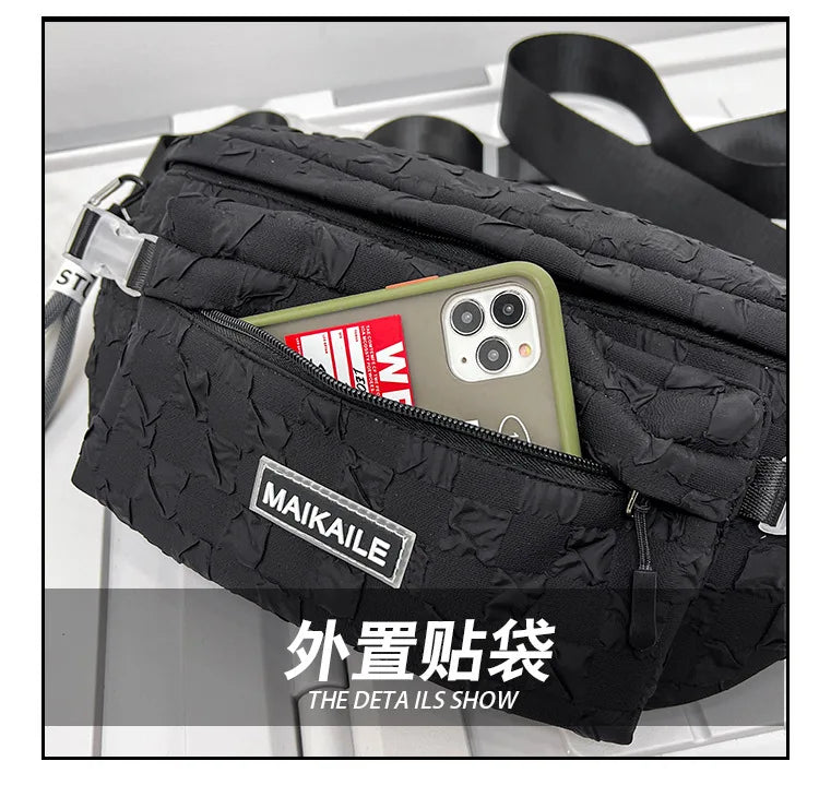Black plaid crossbody chest bag with a zipper and adjustable strap shown in a white setting.