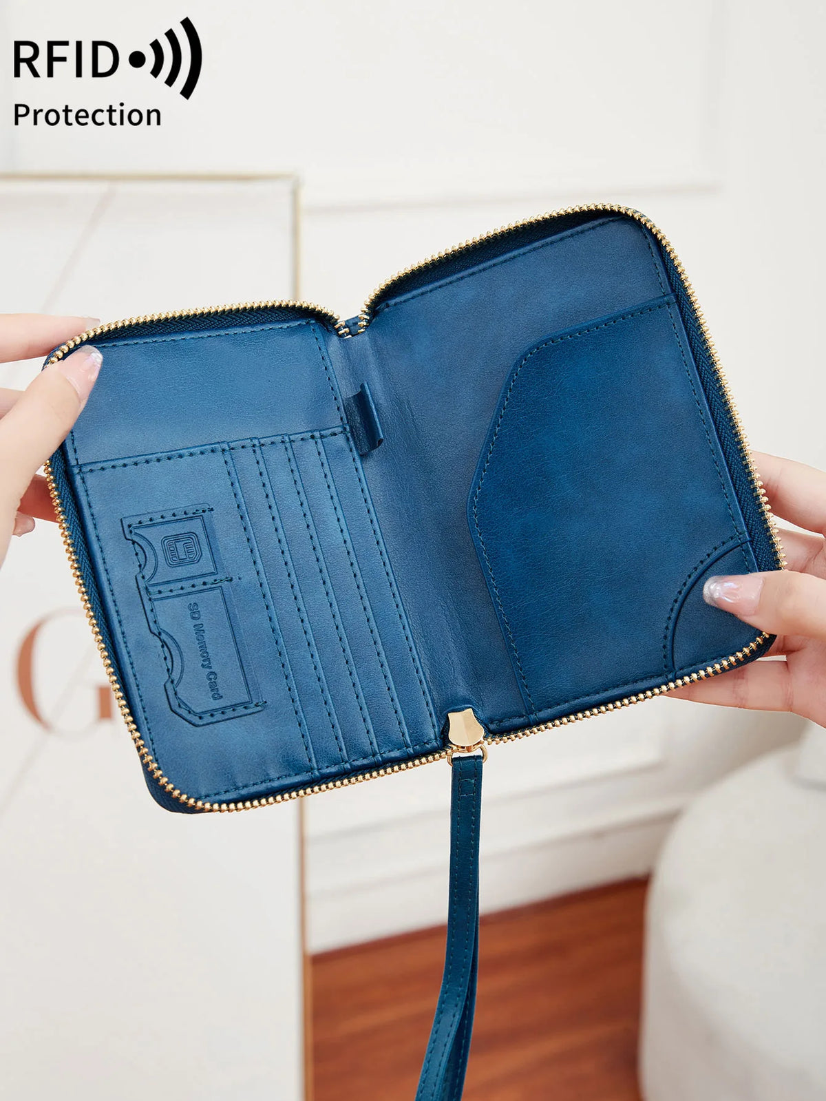 A hand holds an open blue RFID-blocking passport wallet with a zipper closure.