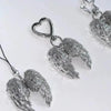 Silver metal angel wing keychain charm with a heart pendant