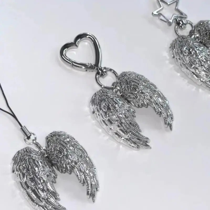 Silver metal angel wing keychain charm with a heart pendant