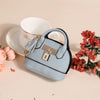 Portefeuille/porte-monnaie en plastique PVC bleu clair de luxe, porte-clés, posé sur une surface beige à côté d'une tasse bla