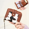A brown leather bifold wallet with a white cow print design is shown being held, demonstrating RFID protection.