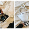 A white PU leather crossbody saddle bag with a silver chain strap is shown open and closed against a white background.