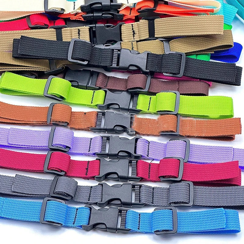 A collection of various colored adjustable tactical backpack chest strap harnesses.