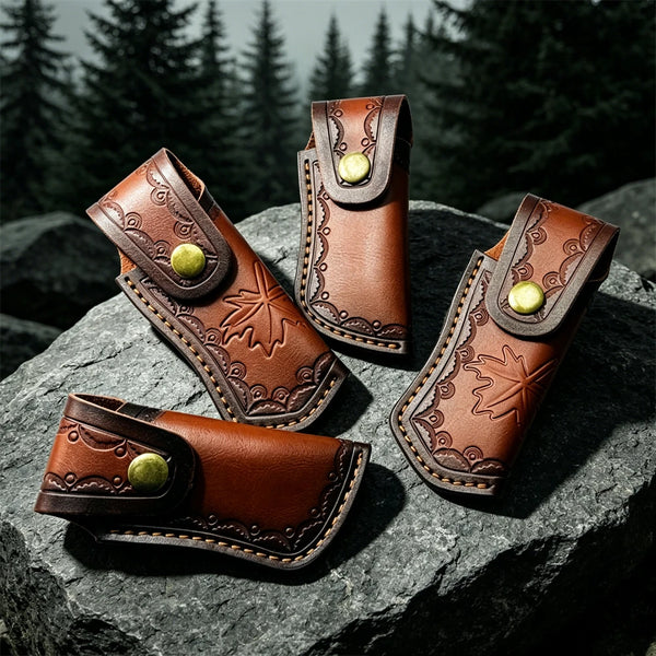 Three brown leather knife sheaths with decorative stitching and brass buttons resting on a dark rock.