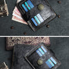 A black floral genuine leather card wallet with a gold accent, shown open on a dark gray background.
