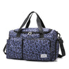 A purple leopard print travel duffel bag with a separate shoe compartment.