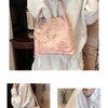 Bolso de seda jacquard rosa con borlas, sostenido por una mujer con top de encaje blanco.
