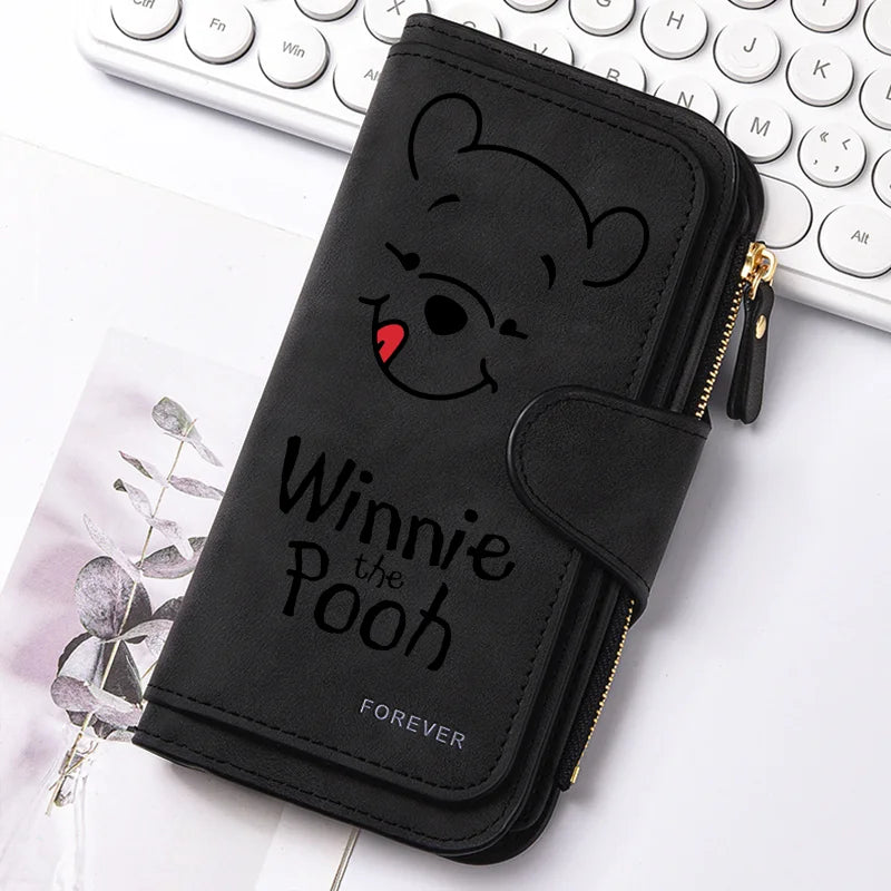 Black zippered pouch featuring a Winnie the Pooh bear design resting on a white surface.