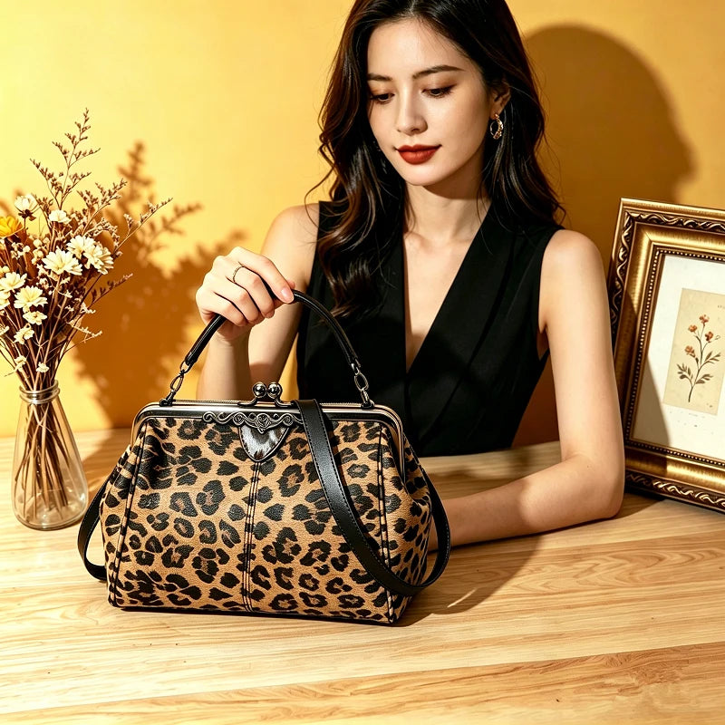 A woman holds a leopard print faux leather handbag with a top handle and crossbody strap on a wooden surface.