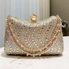 A sparkling gold rhinestone diamond inlay evening clutch bag with a pearl closure.