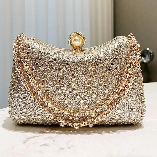 A sparkling gold rhinestone diamond inlay evening clutch bag with a pearl closure.